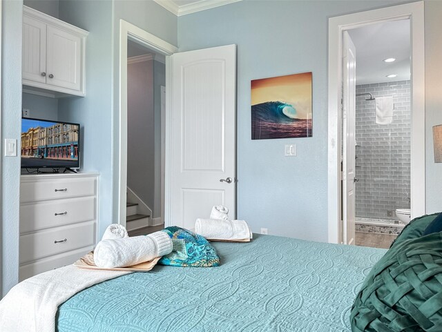 bedroom featuring crown molding, wood finished floors, and ensuite bath