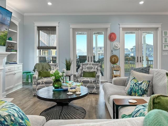 living room featuring crown molding, a wealth of natural light, and light wood-style floors