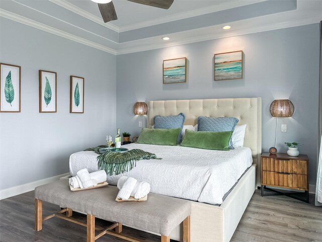 bedroom featuring crown molding, a raised ceiling, baseboards, recessed lighting, and wood finished floors