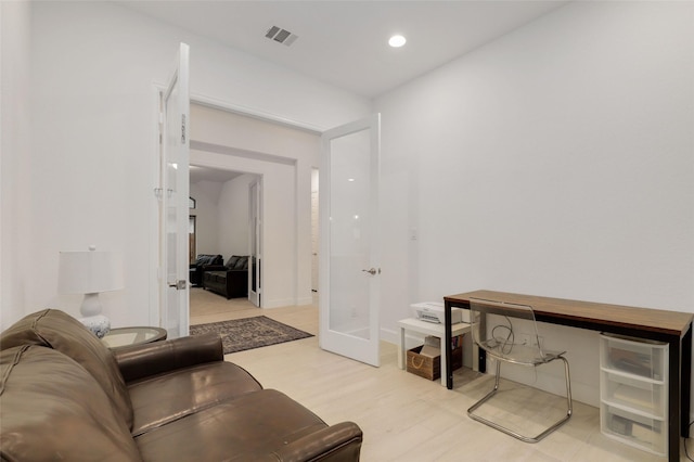 living room with recessed lighting, visible vents, french doors, and light wood-style floors
