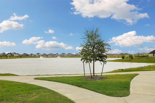 view of property's community with a residential view, a water view, and a lawn