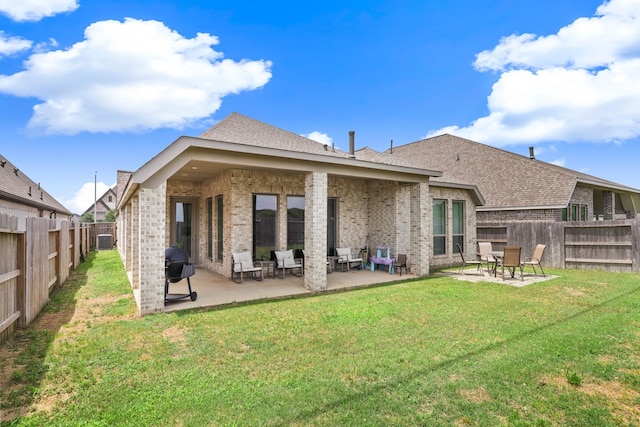 back of house featuring a patio area, a yard, central AC, brick siding, and a fenced backyard