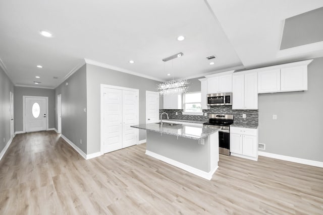 3527 Brook Valley Dr, Brookshire, TX 77423 - kitchen featuring appliances with stainless steel finishes, crown molding, white cabinets, backsplash, and a center island with sink
