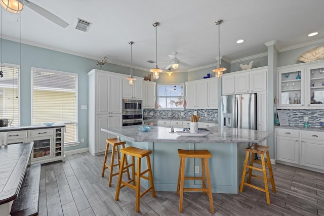 19427 Shores Dr, Galveston, TX 77554 - kitchen featuring white cabinetry, ceiling fan, stainless steel appliances, visible vents, and backsplash