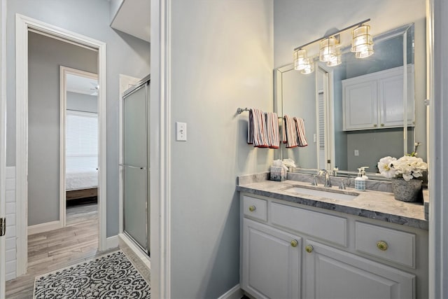 19427 Shores Dr, Galveston, TX 77554 - bathroom featuring baseboards, wood finished floors, a shower stall, and vanity