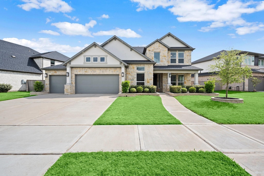 5003 Tanyard Manor Dr, Sugar Land, TX 77479 - craftsman inspired home with concrete driveway, stone siding, stucco siding, a front lawn, and a garage