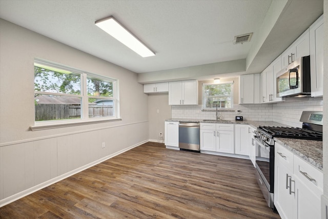 3206 Crossfell Rd, Spring, TX 77388 - kitchen featuring stainless steel appliances, a sink, backsplash, white cabinetry, and dark wood-style flooring