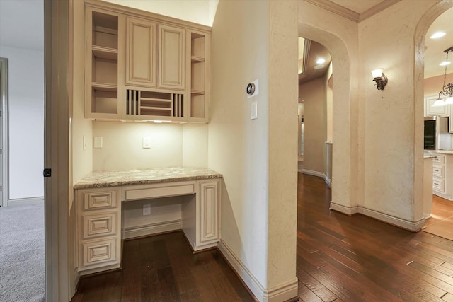 hallway featuring dark wood-type flooring, arched walkways, baseboards, and crown molding