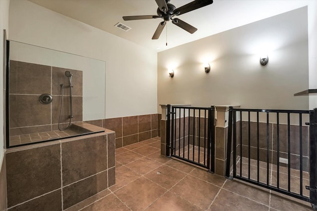 bathroom with visible vents, ceiling fan, tile patterned flooring, and a tile shower