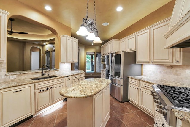 kitchen with a sink, cream cabinets, stainless steel appliances, and custom range hood