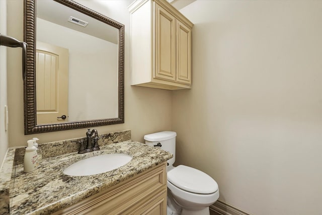 bathroom featuring visible vents, toilet, and vanity