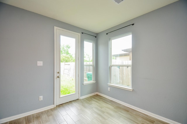 entryway featuring baseboards, a wealth of natural light, and light wood-style floors