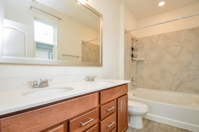 bathroom with bathing tub / shower combination, toilet, double vanity, and a sink