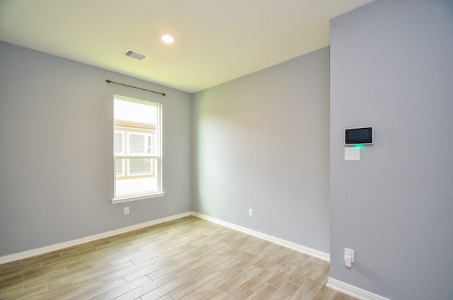 unfurnished room with baseboards, visible vents, light wood-style flooring, and recessed lighting