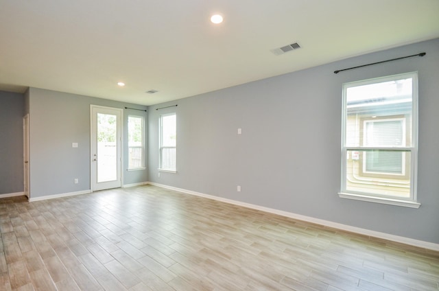 empty room featuring baseboards, visible vents, light wood finished floors, and recessed lighting