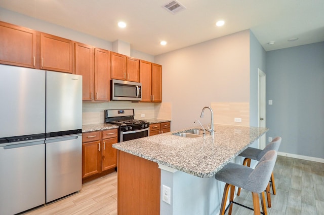 kitchen featuring visible vents, light wood-style floors, appliances with stainless steel finishes, and a sink