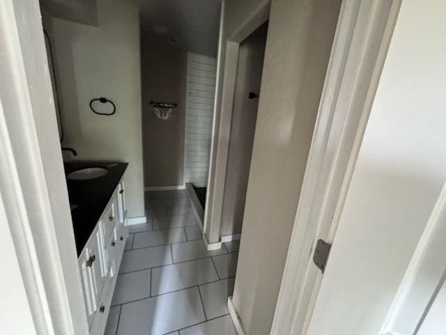 bathroom with tile patterned flooring, a shower stall, vanity, and baseboards