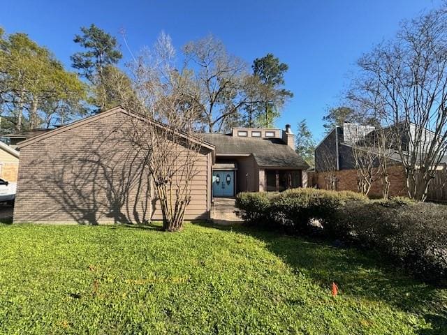 view of front of home featuring a front lawn and a chimney