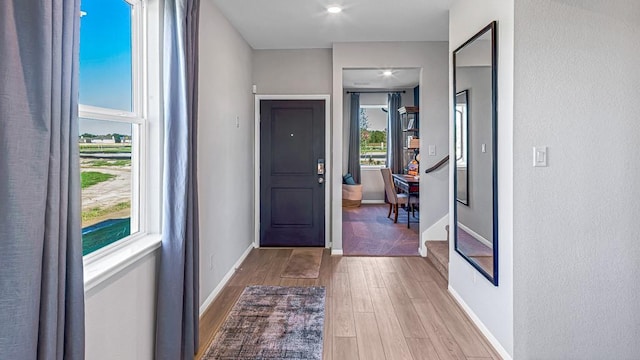 doorway featuring wood finished floors and baseboards