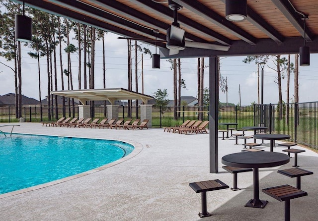 community pool with a patio and fence
