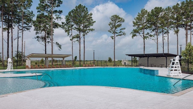 community pool with fence and a patio area