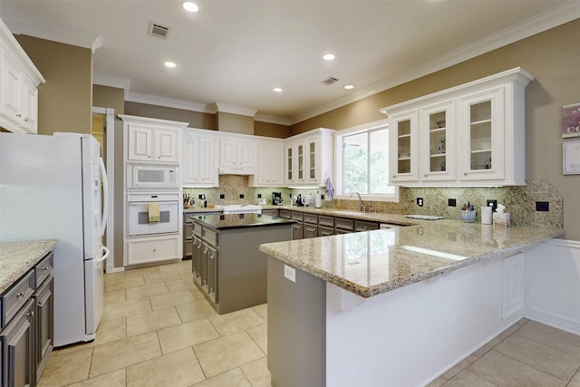 13671 Suzanne Pl, College Station, TX 77845 - kitchen featuring a sink, a peninsula, decorative backsplash, and white appliances