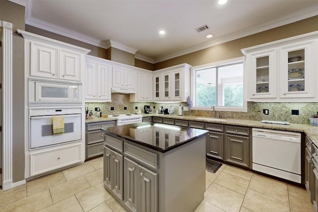 13671 Suzanne Pl, College Station, TX 77845 - kitchen with light tile patterned floors, white cabinets, a sink, white appliances, and gray cabinets