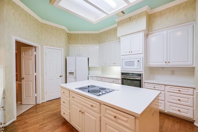13727 Aspen Cove Dr, Houston, TX 77077 - kitchen with white appliances, light wood-style floors, ornamental molding, a center island, and white cabinetry