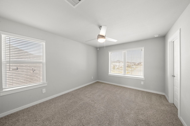 unfurnished room with a ceiling fan, visible vents, carpet, and baseboards
