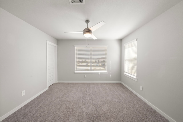 empty room featuring a ceiling fan, baseboards, and carpet floors