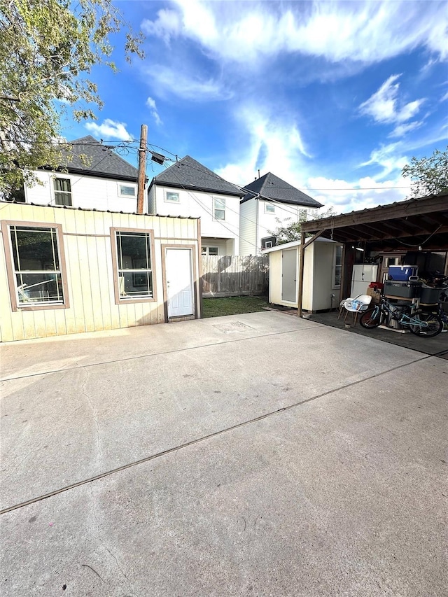 view of home's exterior featuring a storage unit, board and batten siding, fence, and an outbuilding