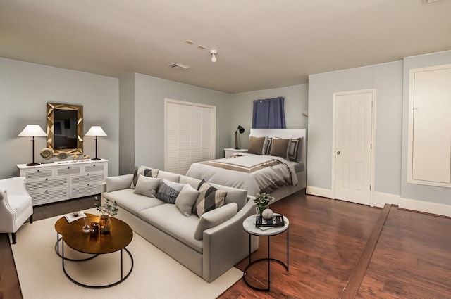 bedroom with visible vents, baseboards, and dark wood finished floors