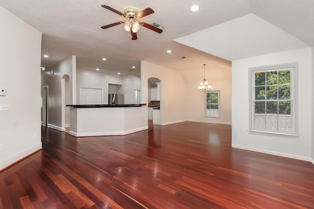 unfurnished living room with baseboards, recessed lighting, arched walkways, ceiling fan with notable chandelier, and dark wood-style floors