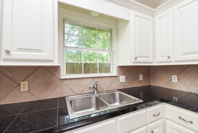 kitchen with white cabinetry, backsplash, tile countertops, and a sink