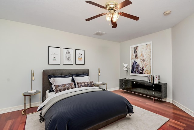 bedroom featuring wood finished floors, visible vents, and baseboards