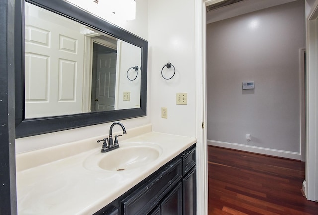 bathroom with baseboards, wood finished floors, and vanity