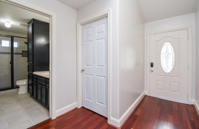 foyer entrance featuring dark wood-type flooring and baseboards