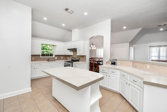 1802 Terry St, Houston, TX 77009 - kitchen featuring stainless steel gas range oven, ventilation hood, tasteful backsplash, light countertops, and vaulted ceiling