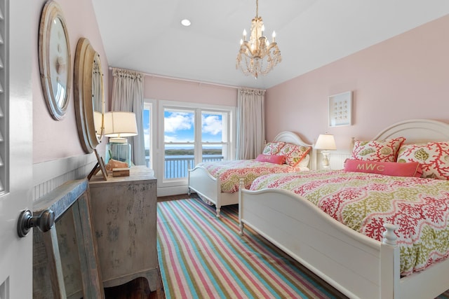 bedroom with a water view and a chandelier