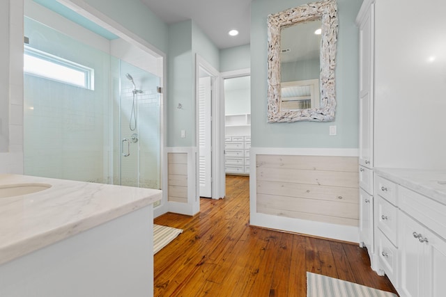 full bath featuring hardwood / wood-style floors, recessed lighting, a shower stall, and vanity