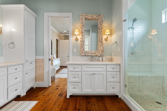 full bathroom with vanity, a shower stall, and wood finished floors