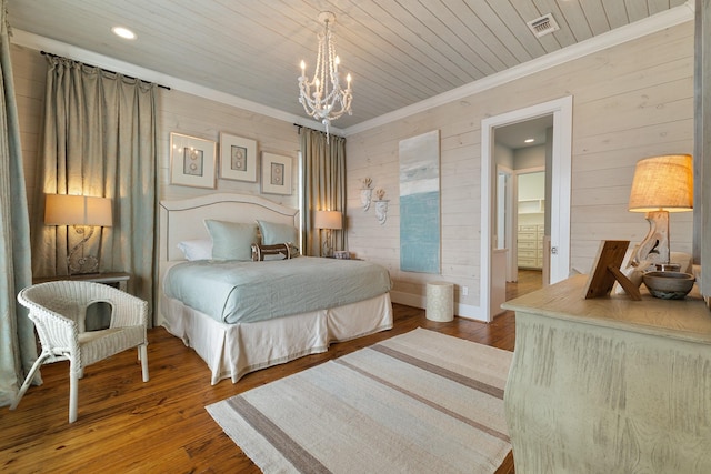 bedroom featuring wood finished floors, wood ceiling, wood walls, ornamental molding, and a notable chandelier