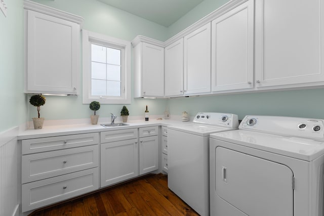 laundry area featuring dark wood-style floors, a sink, cabinet space, and independent washer and dryer