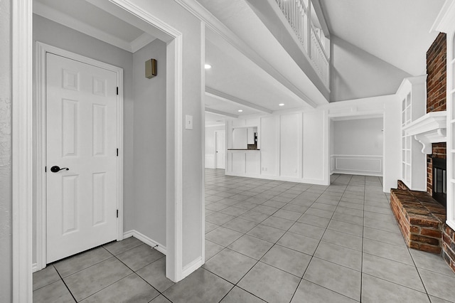interior space featuring recessed lighting, a fireplace, light tile patterned flooring, vaulted ceiling, and a decorative wall