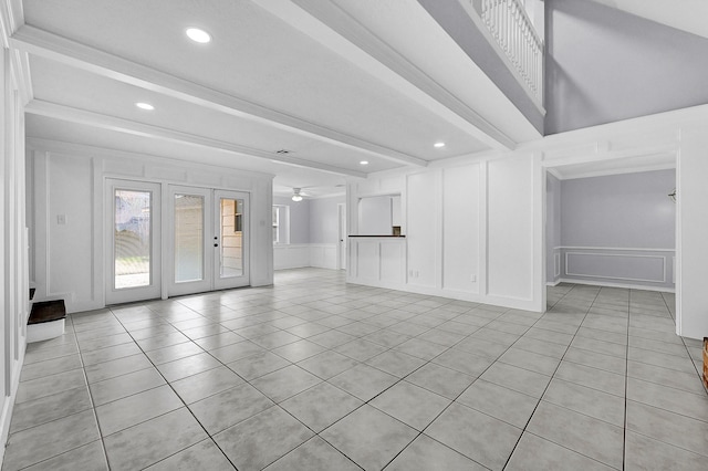 unfurnished living room featuring french doors, recessed lighting, light tile patterned flooring, and a decorative wall