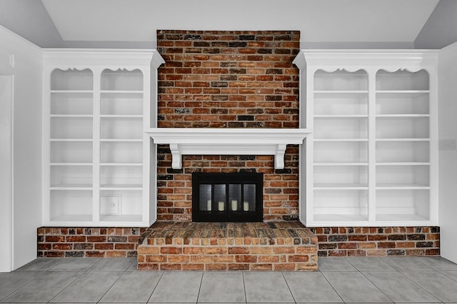 unfurnished living room with built in features, tile patterned flooring, and a fireplace