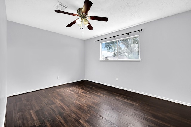 unfurnished room featuring dark wood-style flooring, visible vents, a ceiling fan, and baseboards