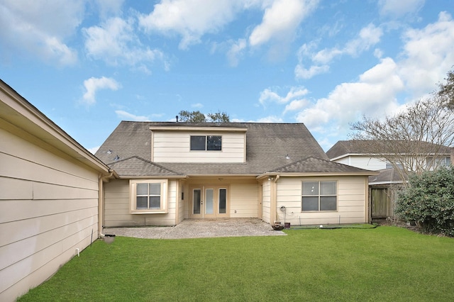 rear view of property with fence, a yard, and a shingled roof