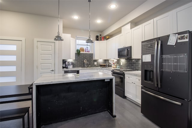 kitchen featuring decorative backsplash, decorative light fixtures, black appliances, white cabinetry, and a center island