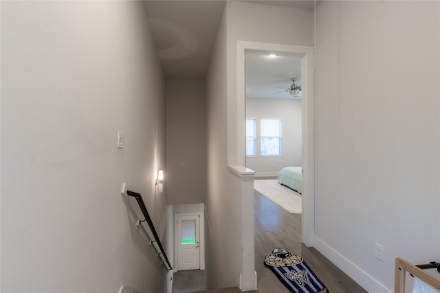 stairs with a ceiling fan, wood finished floors, and baseboards